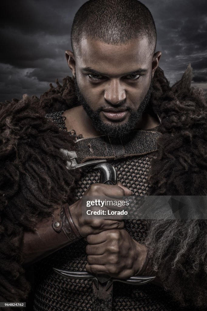 Waffe schwingt Viking inspiriert schwarze Krieger alleine vor einem wolkigen Himmel