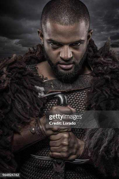 weapon wielding viking inspired black warrior alone in front of a cloudy sky - film poster stock pictures, royalty-free photos & images