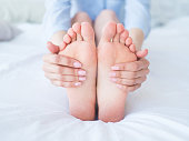 Closeup woman hands doing foot massage