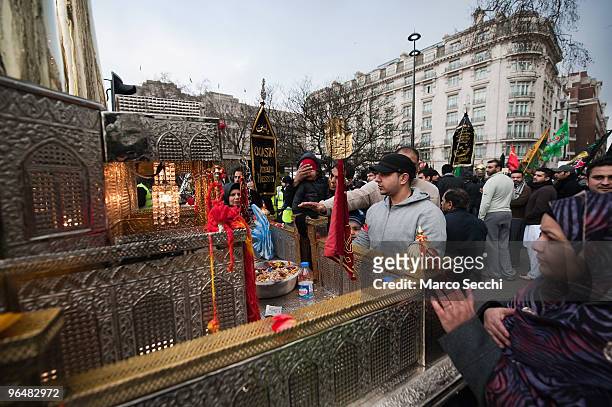 Shiite Muslim devotees pay their respects at a replica model of a shrine of Karbala during the 29th Arbaeen Procession on February 7, 2010 in London,...
