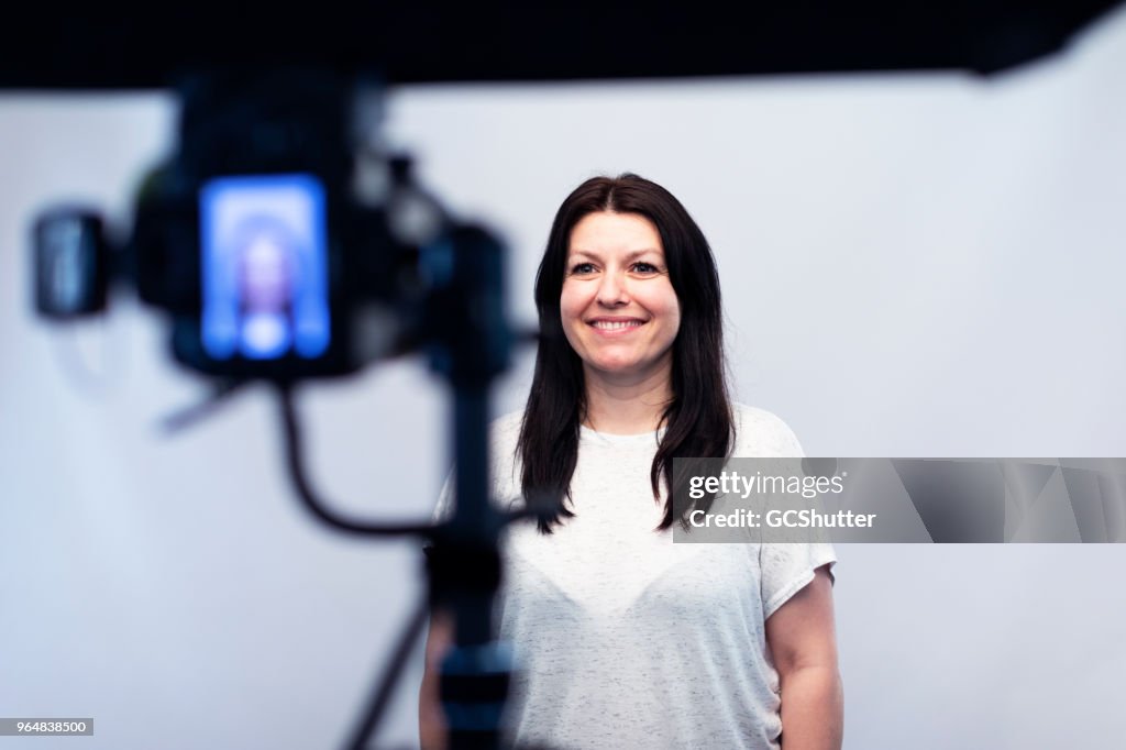 写真スタジオでカメラの前で女性モデル立ち