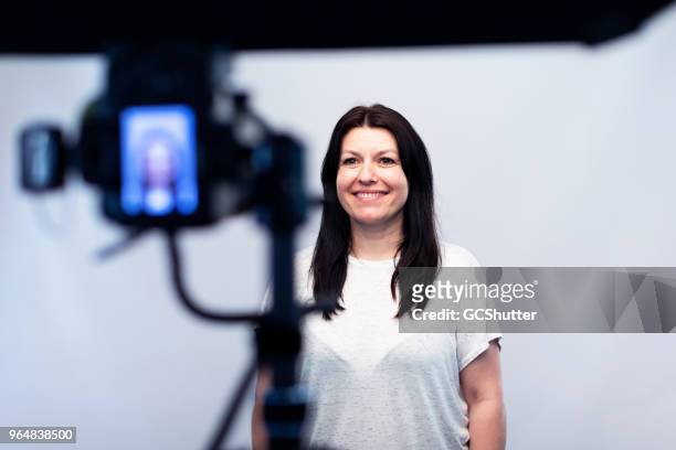 female model standing in front of the camera at the photo studio - photo shoot imagens e fotografias de stock