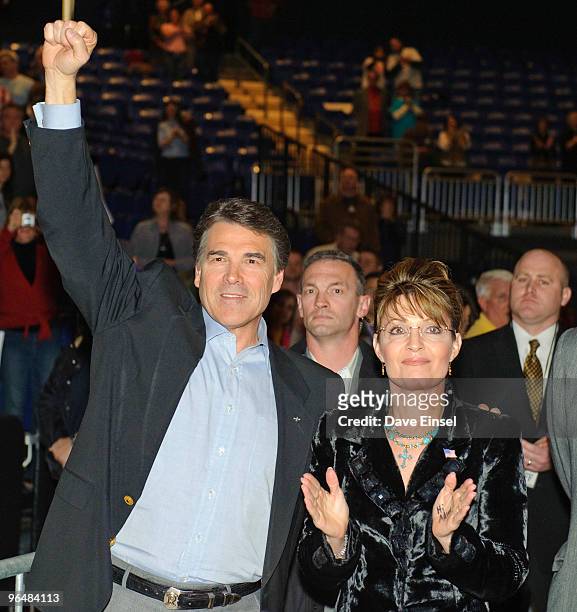 Texas Gov. Rick Perry reacts to the crowd as he waits to take the stage with former Alaska Gov. Sarah Palin during a campaign rally for Perry...