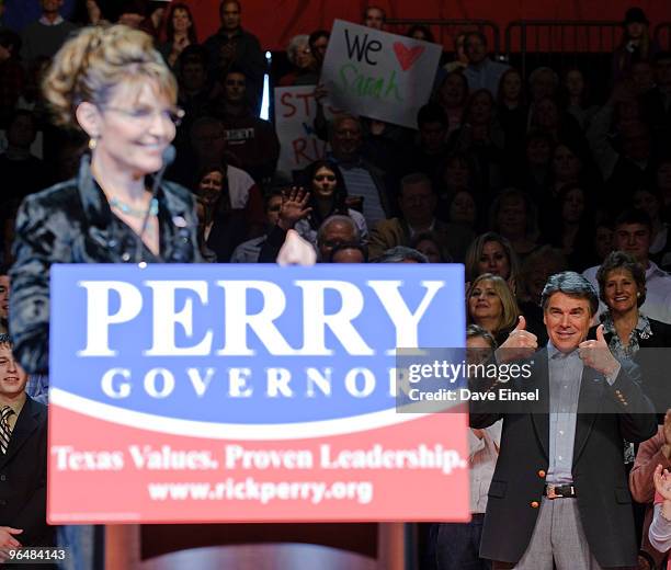 Texas Gov. Rick Perry reacts to a comment by former Alaska Gov. Sarah Palin during a campaign rally for Perry February 7, 2010 in Cypress, Texas....