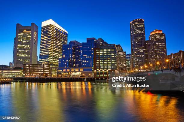 skyline of the waterfront of fort point channel near boston harbour illuminated at dusk - fort point channel foto e immagini stock