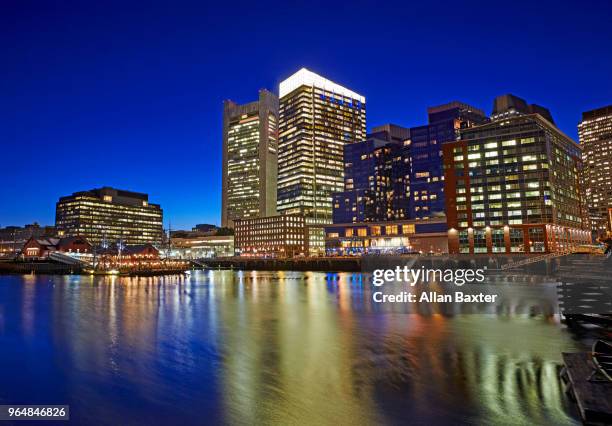 skyline of the waterfront of fort point channel near boston harbour illuminated at dusk - fort point channel foto e immagini stock