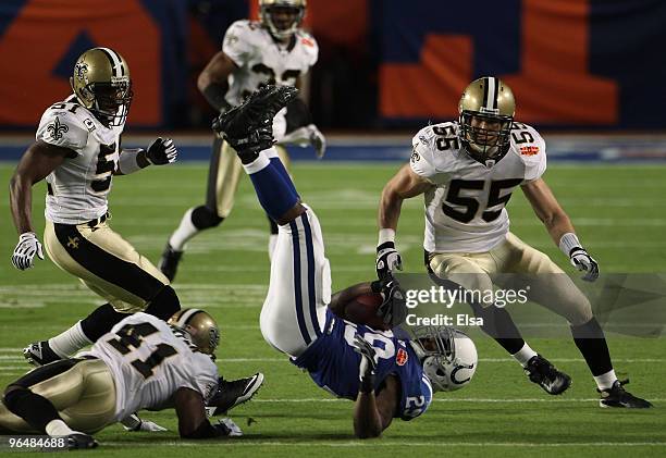 Joseph Addai of the Indianapolis Colts is tackled by Roman Harper of the New Orleans Saints during Super Bowl XLIV on February 7, 2010 at Sun Life...