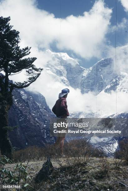 Edmund Hillary in foreground looking up into the mountains, Edmund Hillary in foreground looking up into the mountains of the himalaya from...