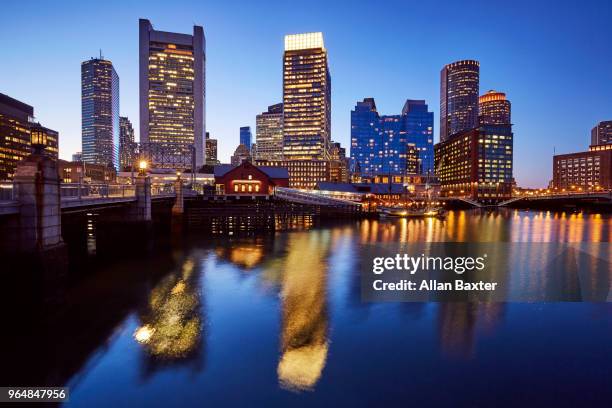 skyline of the waterfront of fort point channel near boston harbour illuminated at dusk - fort point channel foto e immagini stock