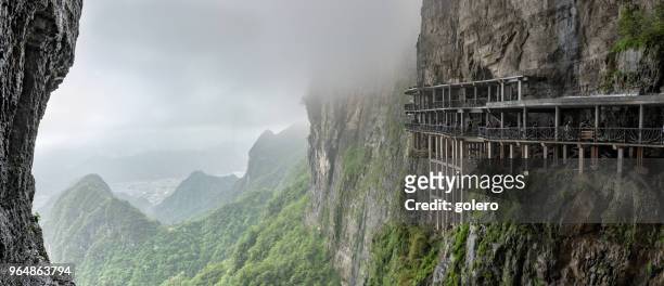 panoramic view from tianmen mountain to the valley with mountain roads - tianmen stock pictures, royalty-free photos & images