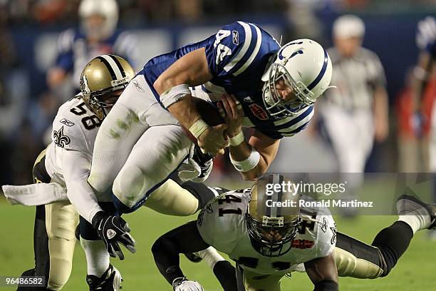 Dallas Clark of the Indianapolis Colts runs with the ball against Roman Harper and Scott Shanle of the New Orleans Saints during Super Bowl XLIV on...