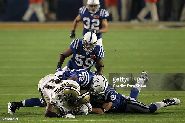 Chris Reis and Roman Harper of the New Orleans Saints fight for the ball with Cody Glenn and Hank Baskett of the Indianapolis Colts after a onside...