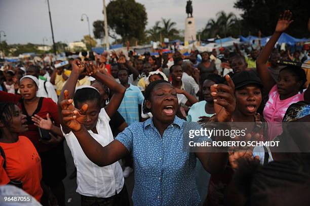 To go with scene story Haiti-quake-religion A Haitian woman sings in prayer with others during a mass at an intersection near the presidential palace...