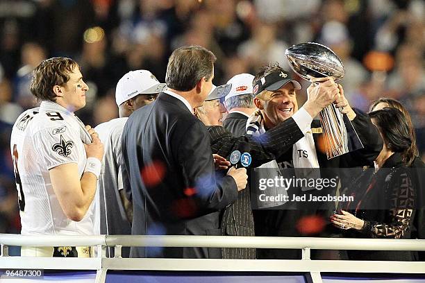 Head coach Sean Payton of the New Orleans Saints holds up the Vince Lombardi Trophy as Drew Brees looks on after defeating the Indianapolis Colts...