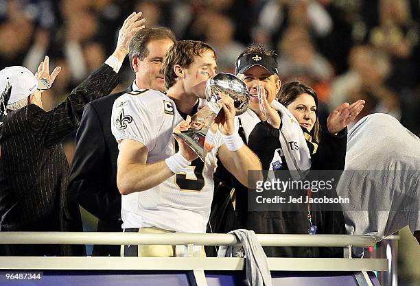Drew Brees of the New Orleans Saints kisses the Vince Lombardi Trophy as head coach Sean Payton looks on after defeating the Indianapolis Colts...