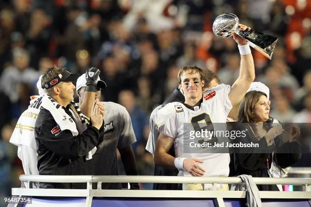 Drew Brees of the New Orleans Saints holds up the Vince Lombardi Trophy as head coach Sean Payton looks on after defeating the Indianapolis Colts...