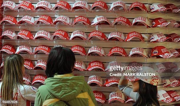 Family looks at caps for sale in the Russian Winter Olympic fans section of the Hudson Bay department store in downtown Vancouver on February 7,...