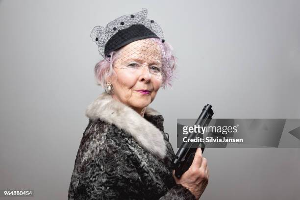 senior gangster lady holding gun - female gangster stock pictures, royalty-free photos & images