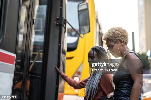two businesswoman getting on the bus, brazil - veículo terrestre comercial imagens e fotografias de stock