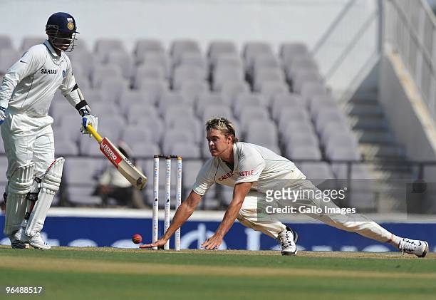 Paul Harris of South Africa fields off his own bowling with Badrinath of India backing-up during day three of the First Test between India and South...
