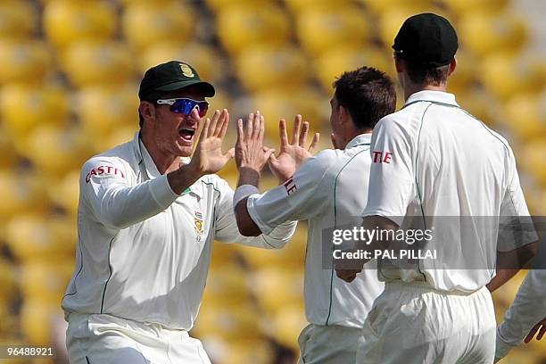 South African cricket captain Graeme Smith celebrates with teammate Dale Steyn on the wicket of Indian cricketer Sachin Tendulkar on the third day of...