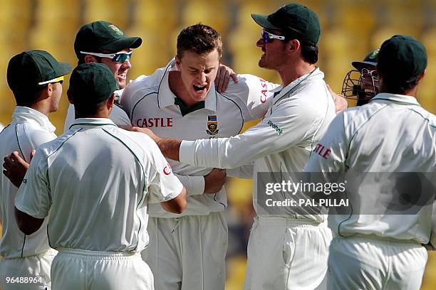 South African cricketer Morne Morkel celebrates with teammates the wicket of Indian cricketer Gautam Gambir on the third day of the first cricket...