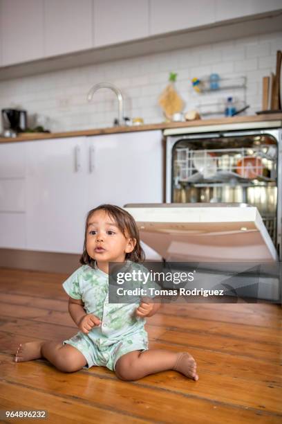 toddler sitting on the floor in front of the dishwasher - dishwasher front photos et images de collection