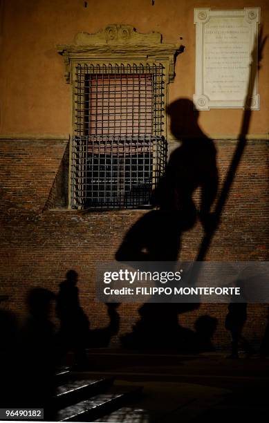 The shadow of the statue of Poseidon is seen central Bologna's Piazza Grande on February 7, 2010. AFP PHOTO / Filippo MONTEFORTE