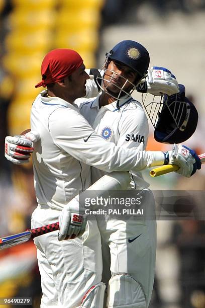 Indian cricketer Virender Sehwag is hugged by teammate Subramaniam Badrinath as the former completes his century on the third day of the first...