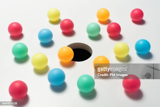 multi colored balls around hole - gelegenheit stock-fotos und bilder