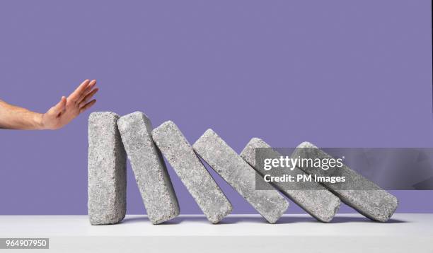 man's hand stopping domino effect - rejection stock-fotos und bilder