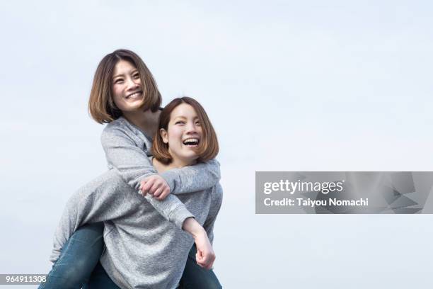 twin sisters playing together - asian twins stockfoto's en -beelden