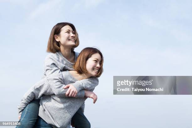 twin sisters playing together - asian twins stockfoto's en -beelden