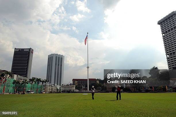 Tourists walk on the green grass of the Dataran Merdeka "Independence square" in Kuala Lumpur on February 6, 2010. A 100 metre-high flagpole rising...