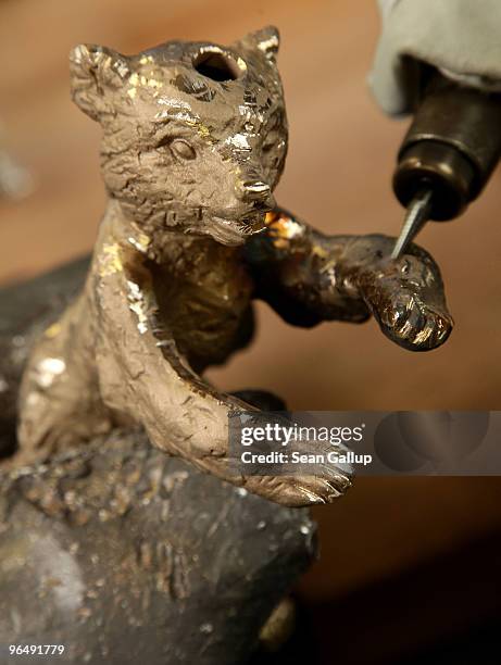 Berlinale Bear lies clamped in a vice as a metal crafts worker shaves off casting remains from its arm at the Hermann Noack casting foundry on...
