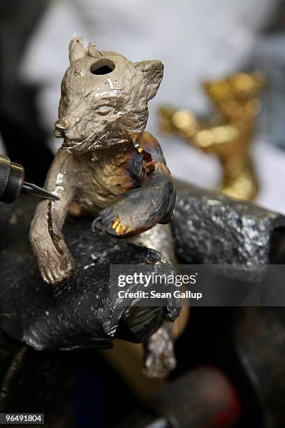 Berlinale Bear lies clamped in a vice as a metal crafts worker shaves off casting remains from its arm at the Hermann Noack casting foundry on...