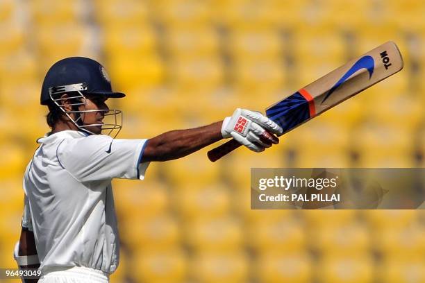 Indian cricketer Subramaniam Badrinath raises his bat after scoring a half century at his debut match on the third day of the first cricket Test...