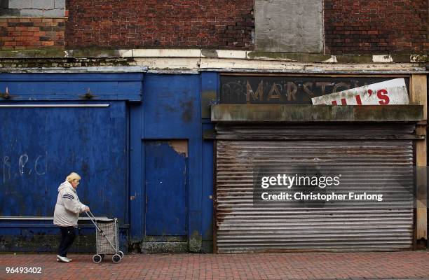 Woman walks past a boarded up shops on January 26, 2010 in Bilston, United Kingdom. As the UK gears up for one of the most hotly contested general...