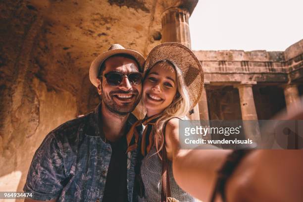 giovane coppia di turisti che scatta selfie all'antico monumento in italia - turista foto e immagini stock