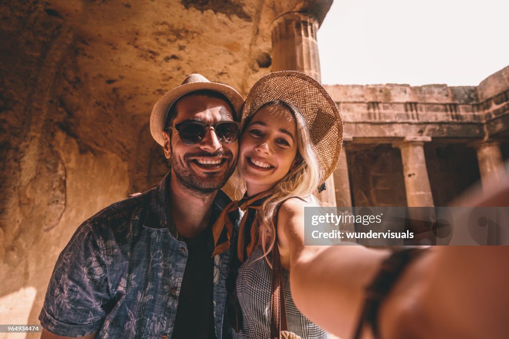 Young tourists couple taking selfies at ancient monument in Italy