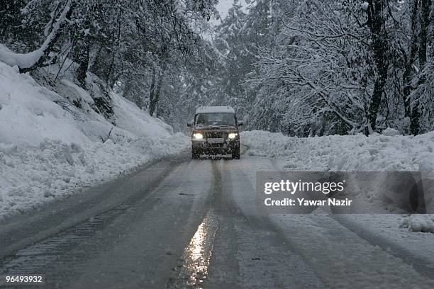 Vehicle carrying tourists drives on a snow covered road during a heavy snowfall on February 08, 2010 In Tangmarg about 40 kms 25 miles west of...