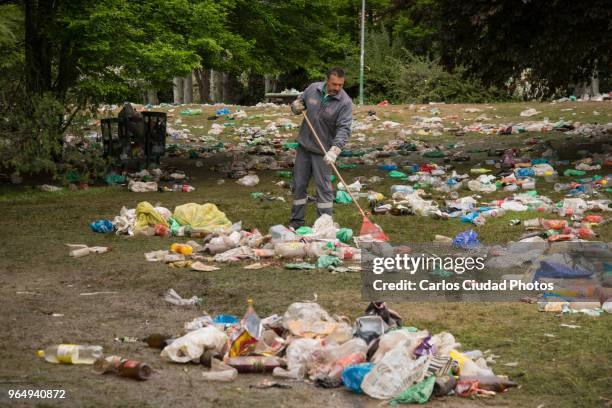 municipal cleaner sweeping rubbish in a green area of madrid, spain - cleaning after party imagens e fotografias de stock