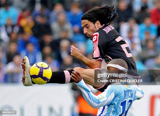 Deportivo Coruna's midfielder Ivan Perez vies for the ball with Malaga's defender Mtiliga during their Spanish league football match at La Rosaleda's...