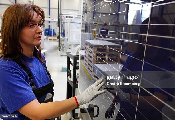 Employee Jana Boehme inspects solar panels at the Solarworld AG plant in Freiberg, Germany, on Monday, Feb. 8, 2010. Germany's solar industry said...