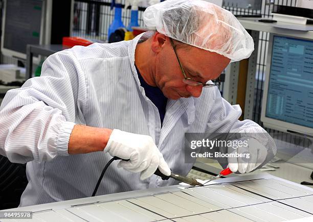 Wilhelm Juerk inspects solar wafers at the Solarworld AG plant in Freiberg, Germany, on Monday, Feb. 8, 2010. Germany's solar industry said the...
