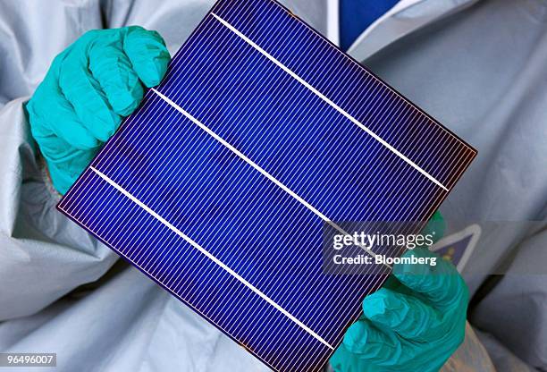 An employee shows a solar wafer at the Solarworld AG plant in Freiberg, Germany, on Monday, Feb. 8, 2010. Germany's solar industry said the...