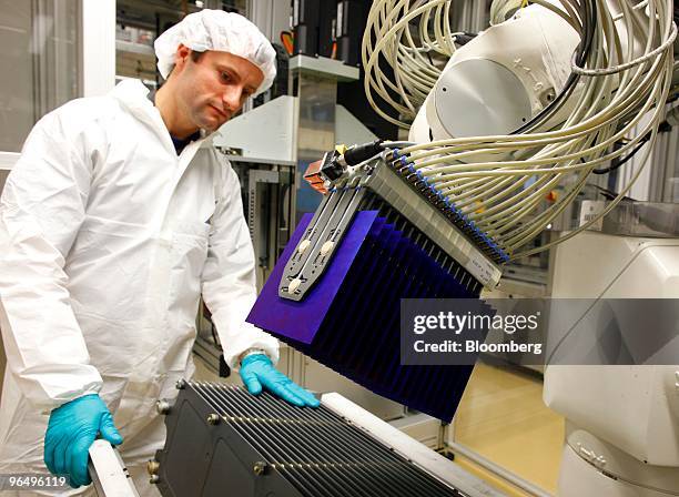 Andre Seifert inspects a machine used to sort solar wafers for solar panels at the Solarworld AG plant in Freiberg, Germany, on Monday, Feb. 8, 2010....