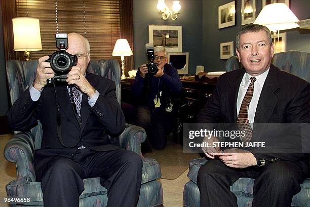 Attorney General nominee John Ashcroft looks at the photographers as US Senator Patrick Leahy, D-VT, uses a photographer's camera to take a picture...