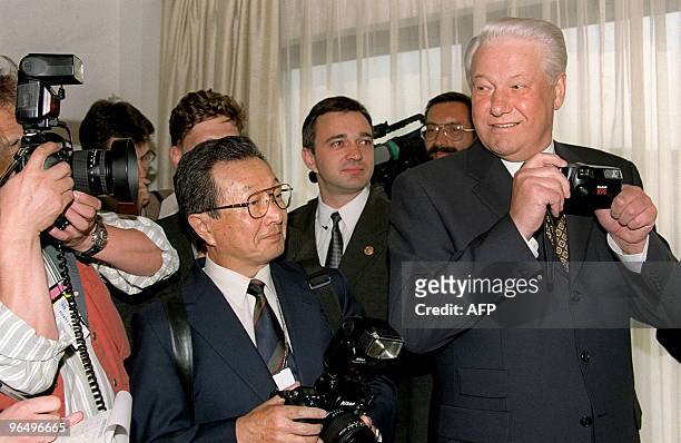 Russian President Boris Yeltsin plays around with a camera with Japanese photographers while waiting for Japanese Prime Minister Ryutaro Hashimoto 15...