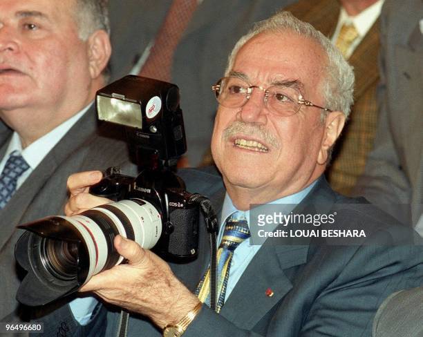 Syrian Defence Minister Gen. Mustafa Tlass holds an AFP photo-journalist's camera during a lecture for Palestinian poet Samih al-Kassem 18 November...